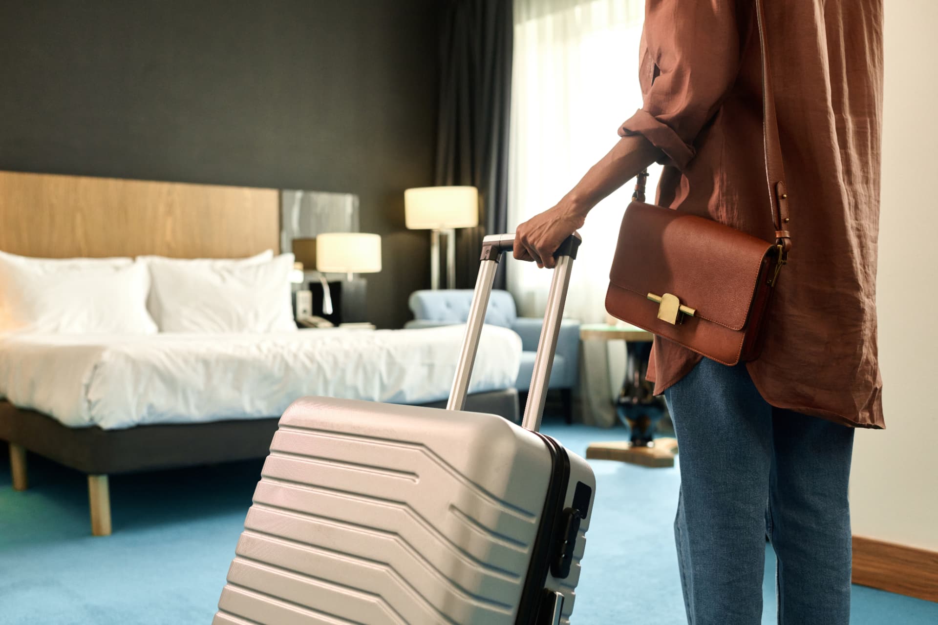 Traveler with a rolling suitcase arriving at a hotel room