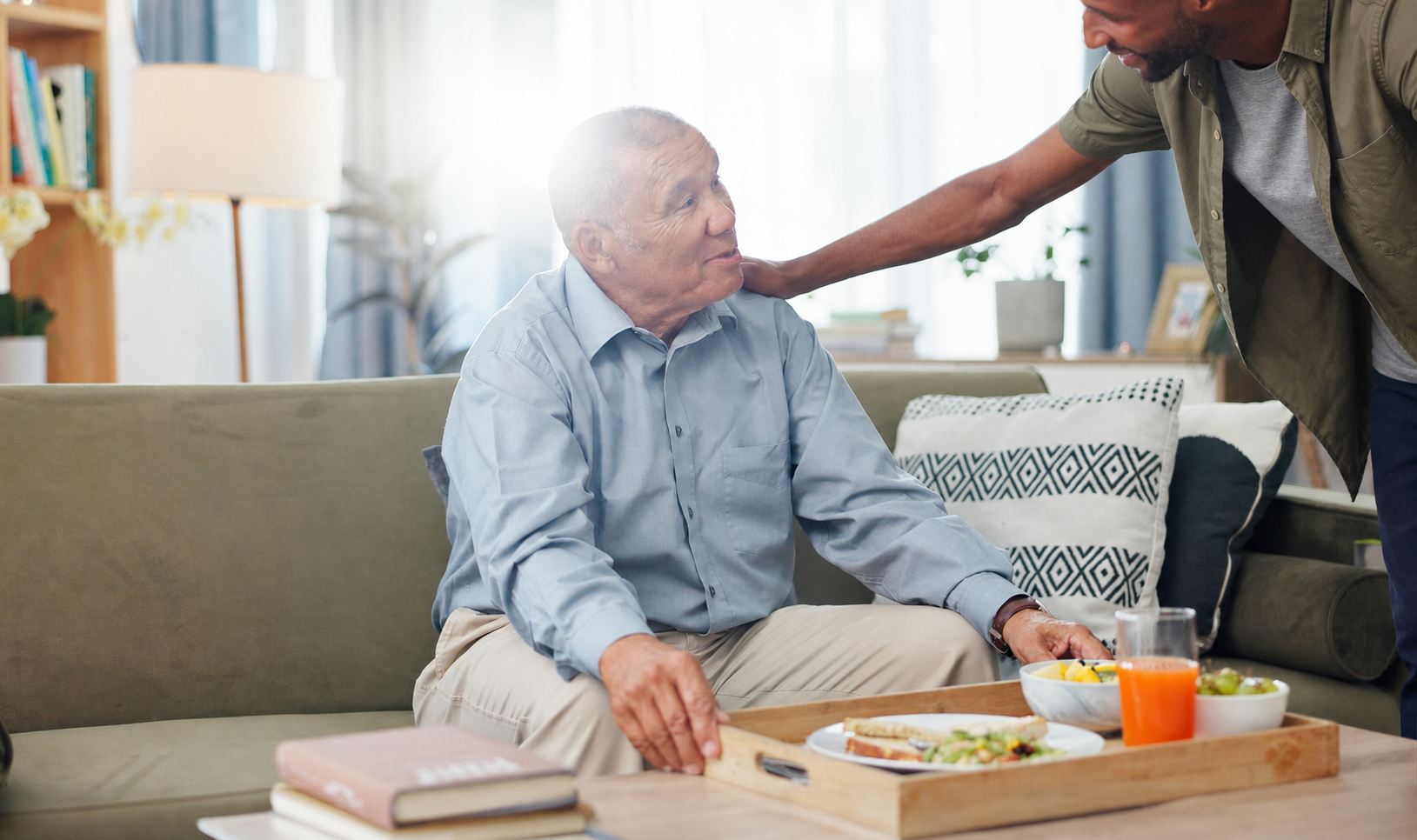 Caregiver bringing a meal to an older family member at home